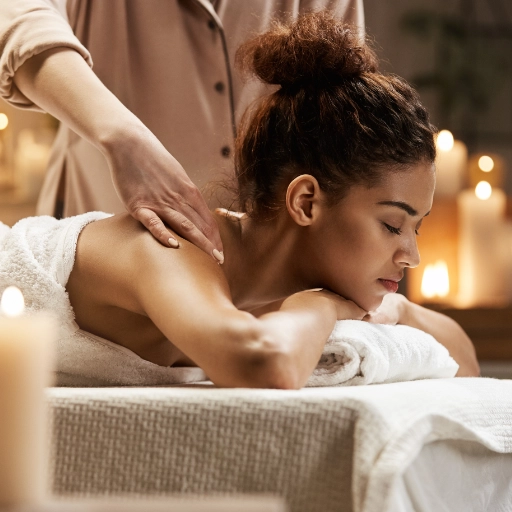 mains massant les épaules du femme allongée